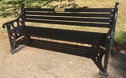 Black iron bench in a park.