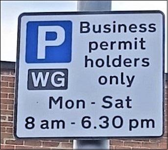 Parking sign with a white P in a blue square saying business permit holders only.