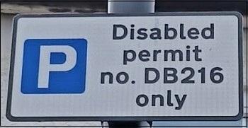Parking sign with white P in blue square saying disabled permit only.