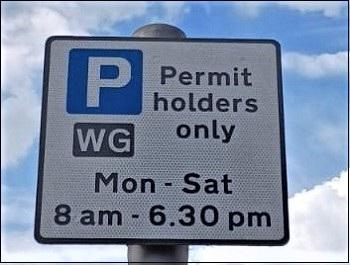 Parking sign with a white P in a blue square saying permit holders only.