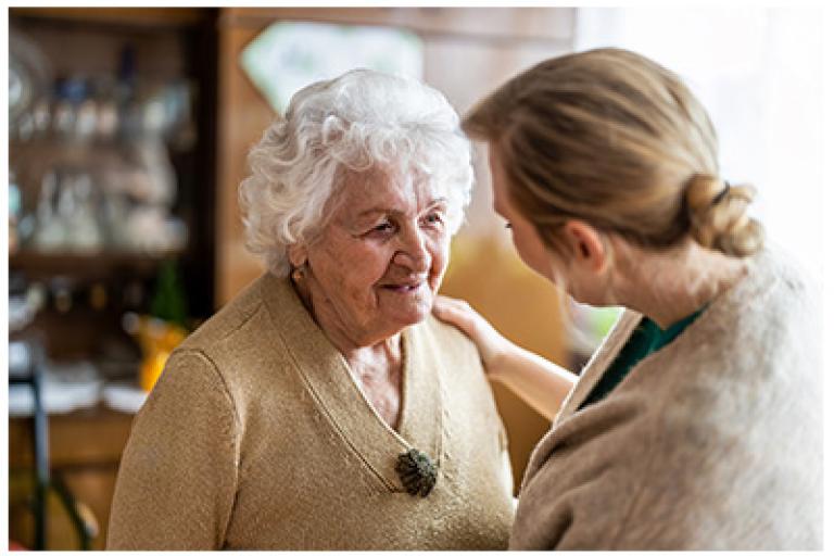Elderly woman looking at younger woman smiling